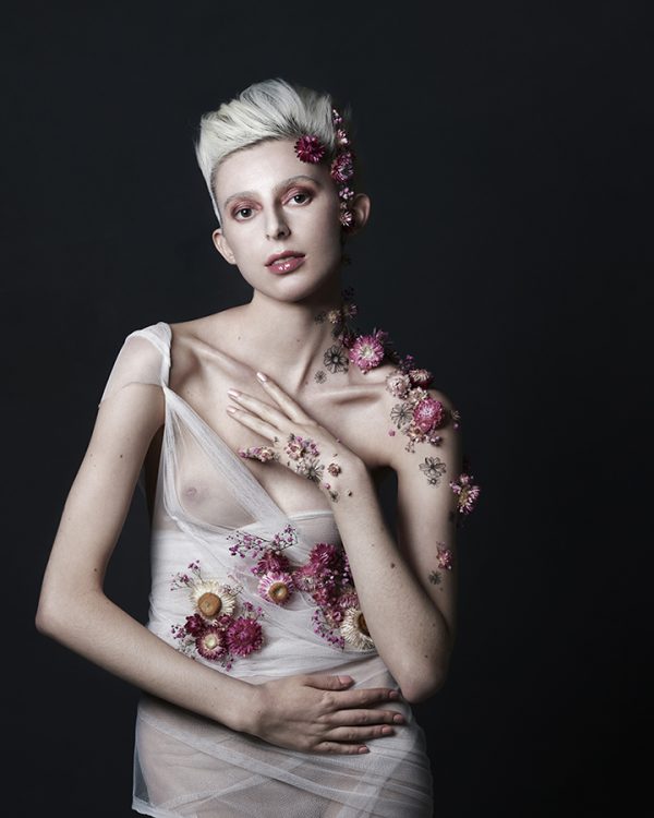 Beauty portrait of a woman covered in flowers